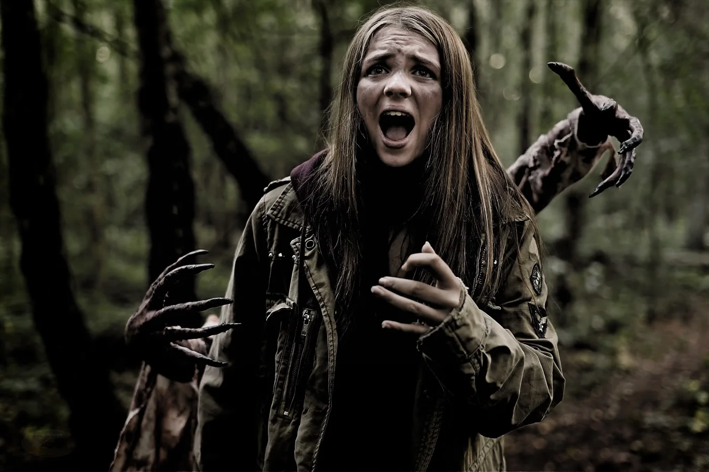 A girl in a khaki jacket screams in a dark forest as clawed hands reach towards her from both sides